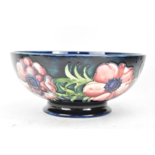 86 - A mid 20th century Walter Moorcroft bowl in the anemone design, on a blue ground and raised on a cir... 