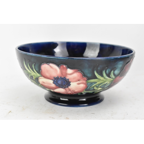 86 - A mid 20th century Walter Moorcroft bowl in the anemone design, on a blue ground and raised on a cir... 