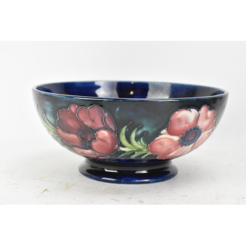 86 - A mid 20th century Walter Moorcroft bowl in the anemone design, on a blue ground and raised on a cir... 