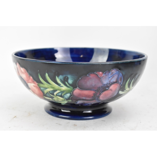 86 - A mid 20th century Walter Moorcroft bowl in the anemone design, on a blue ground and raised on a cir... 