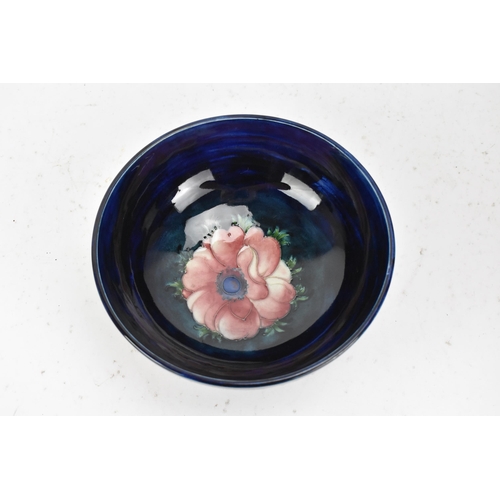 86 - A mid 20th century Walter Moorcroft bowl in the anemone design, on a blue ground and raised on a cir... 