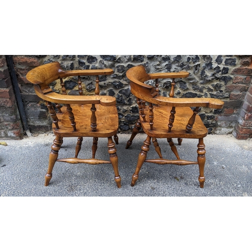 88 - A pair of Stewart Linford elm and ash captains armchairs, each having a curved top rail, spade arm s... 