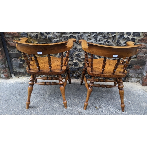 88 - A pair of Stewart Linford elm and ash captains armchairs, each having a curved top rail, spade arm s... 