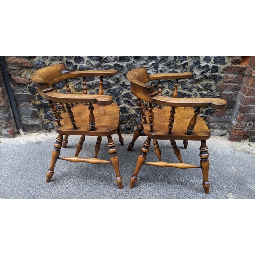 89 - A pair of Stewart Linford elm and ash captains armchairs, each having a curved top rail, spade arm s... 