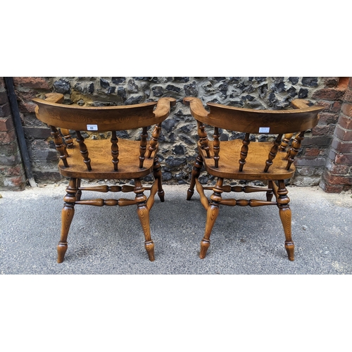 89 - A pair of Stewart Linford elm and ash captains armchairs, each having a curved top rail, spade arm s... 