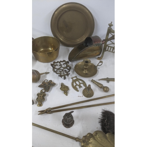 111 - A mixed lot of brass wear to include two saucepans, fine side dogs, fine side items, a lantern, bell... 