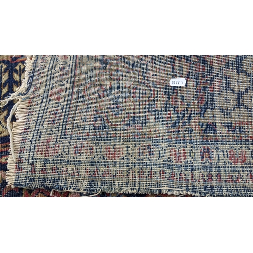 14 - A Middle Eastern Kirman hand woven rug having a floral design on a red field with multi-guard boarde... 