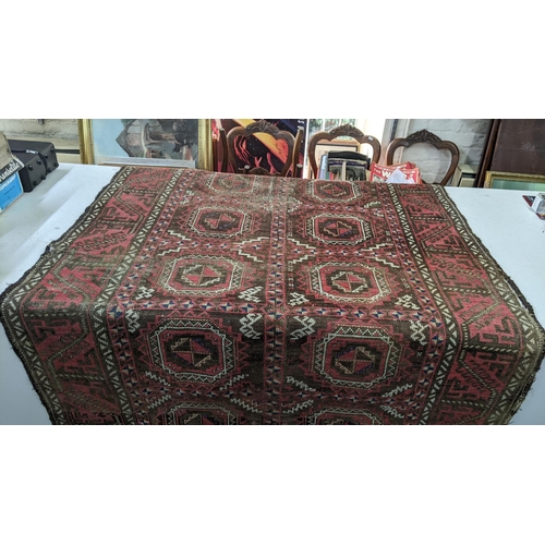 15 - A Persian hand woven red ground rug having geometric designs and tasselled ends, 224cm x 123cm w
Loc... 