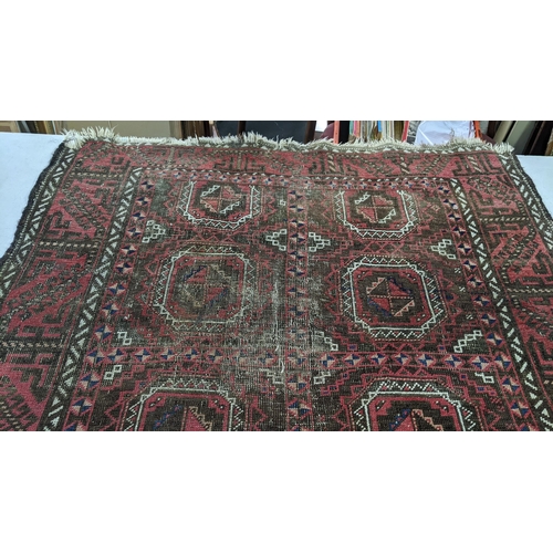 15 - A Persian hand woven red ground rug having geometric designs and tasselled ends, 224cm x 123cm w
Loc... 