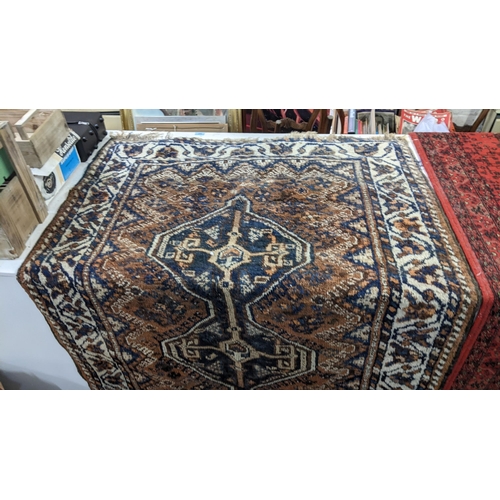 16 - Two rugs to include an Afghan brown and blue ground hand woven rug, 126cm x 112cm, and a machine wov... 