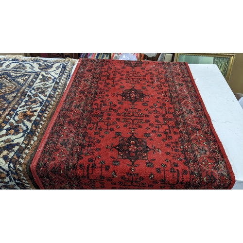 16 - Two rugs to include an Afghan brown and blue ground hand woven rug, 126cm x 112cm, and a machine wov... 