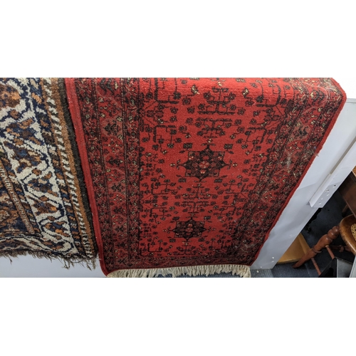 16 - Two rugs to include an Afghan brown and blue ground hand woven rug, 126cm x 112cm, and a machine wov... 