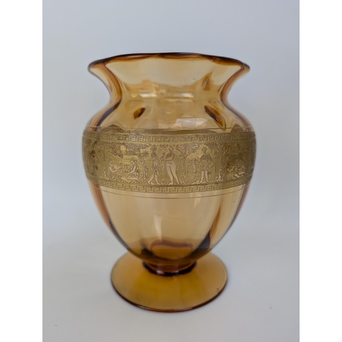 106A - A Val St Lambert amber coloured glass vase decorated in gilt with a repeated classical scene, signed... 