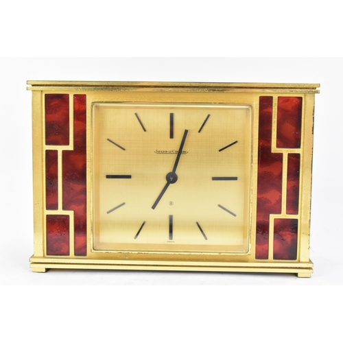 12 - A Jaeger LeCoultre gilt metal table clock, circa 1950s, of rectangular form, the case with red lacqu... 