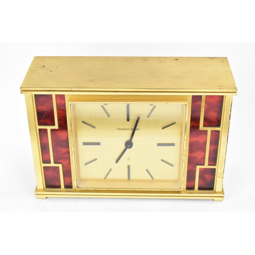 12 - A Jaeger LeCoultre gilt metal table clock, circa 1950s, of rectangular form, the case with red lacqu... 