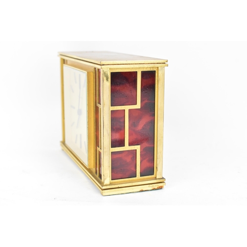 12 - A Jaeger LeCoultre gilt metal table clock, circa 1950s, of rectangular form, the case with red lacqu... 