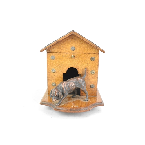 159 - An early 20th century oak novelty cigar and music box, in the form of a kennel with patinated metal ... 