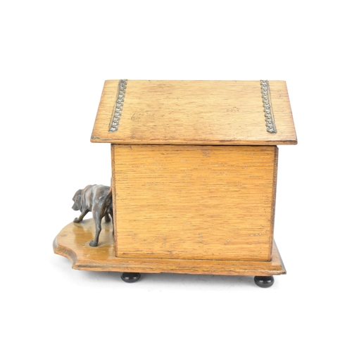 159 - An early 20th century oak novelty cigar and music box, in the form of a kennel with patinated metal ... 