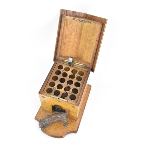 159 - An early 20th century oak novelty cigar and music box, in the form of a kennel with patinated metal ... 