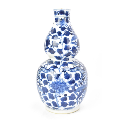 184 - A Chinese late Qing dynasty blue and white double gourd vase, late 19th century, decorated with a fo... 