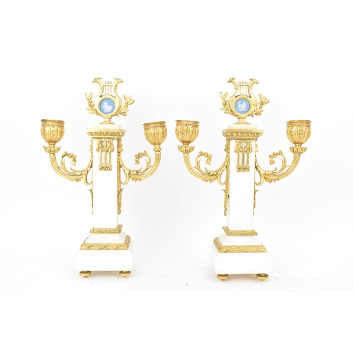 64 - A late 19th century French gilt metal and white marble portico clock and two garnitures, the clock h... 