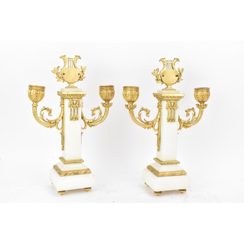 64 - A late 19th century French gilt metal and white marble portico clock and two garnitures, the clock h... 