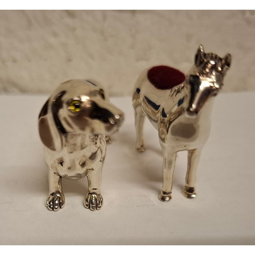 42 - Two silver pin cushions; one fashioned as a horse 3.5cm wide and the other as a dachshund 4.5cm wide... 