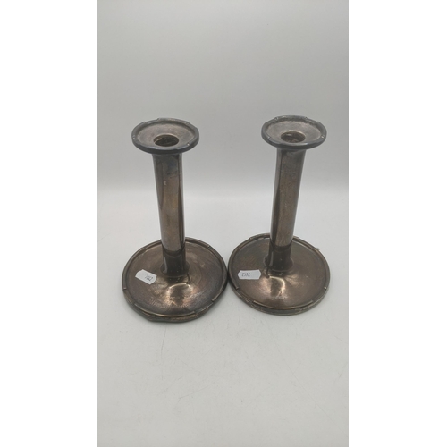 5 - A pair of A and J Zimmerman silver weighted candlesticks on circular bases inscribed 'Woodcock cup' ... 