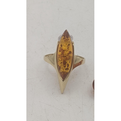 57 - A 14ct yellow gold and amber coloured resin ring 3.7g together with a 9ct gold and amber coloured re... 