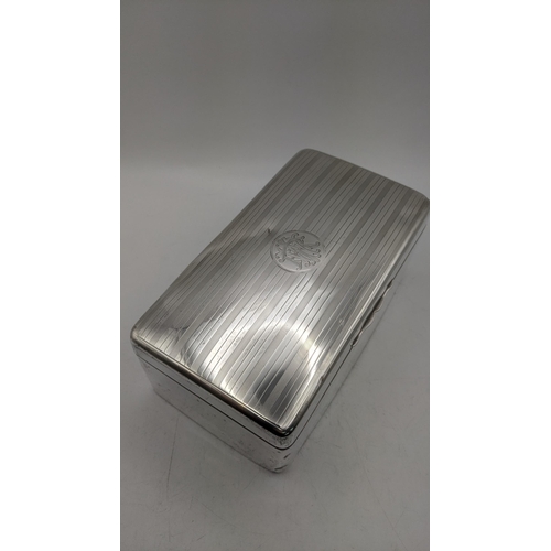 62 - A silver cigarette box having engraved initials to the lid and a gilt and wood lined interior, 7.5cm... 