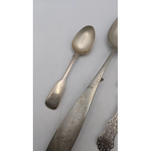 63 - A white metal Continental basting spoon, along with two teaspoons and silver caddy spoon with a flor... 