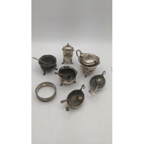 64 - A selection of silver and white metal condiment pots and spoons to include a mustard pot having a bl... 