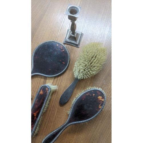 65 - A six-piece silver and tortoiseshell dressing table set A/F to include a comb, mirror, two hand brus... 