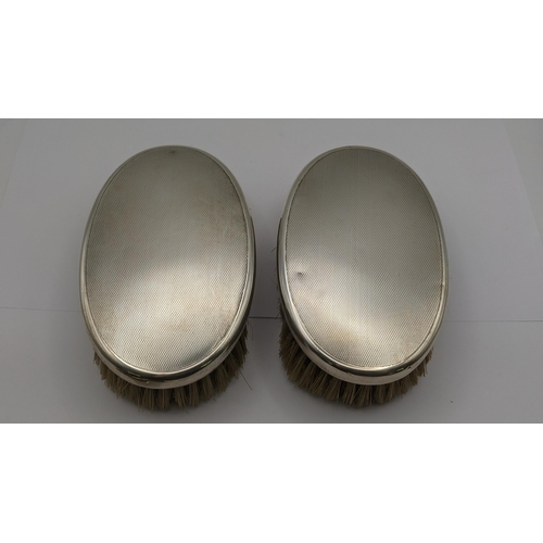 73 - Asprey of London silver to include two dressing table brushes along with a pin dish hallmarked Birmi... 