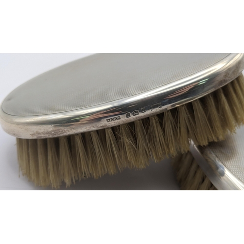 73 - Asprey of London silver to include two dressing table brushes along with a pin dish hallmarked Birmi... 