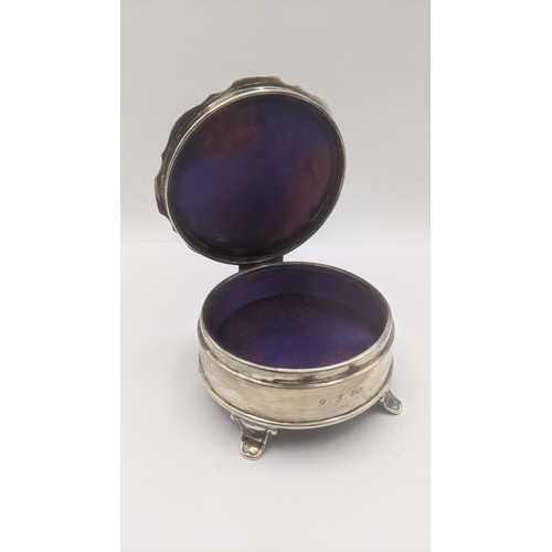 74 - An silver dressing table ring box in circular form on four feet having an engine turned lid engraved... 