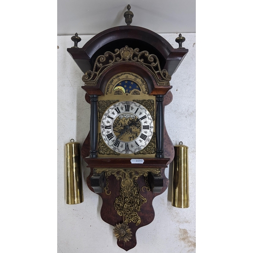 251 - A reproduction of a Dutch Stohl wall hanging clock, having an acorn finial, moon phase and a silvere... 