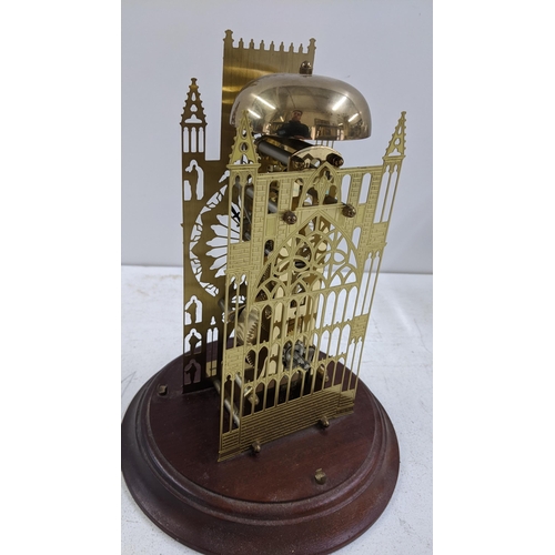 255 - A York Minster Cathedral skeleton clock, mounted on a mahogany base and with a glass dome, 30cm high... 