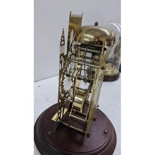 255 - A York Minster Cathedral skeleton clock, mounted on a mahogany base and with a glass dome, 30cm high... 