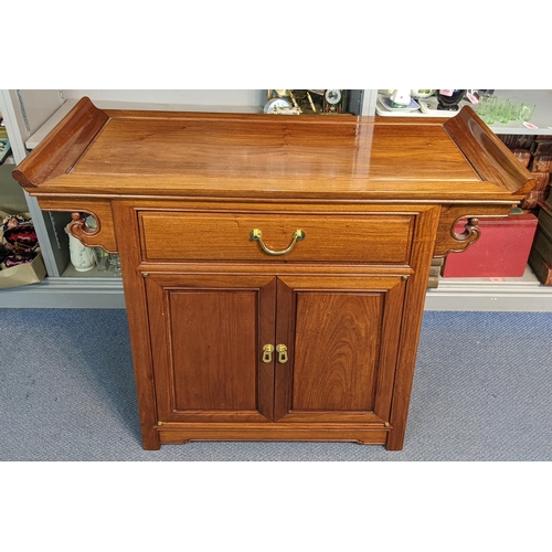 257 - A Chinese exotic wood temple table having a curved top, single drawer and two cupboard doors, 79.5cm... 