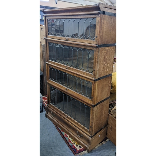 273 - An early 20th century Globe Wernicke oak graduating oak graduating four section bookcase with a draw... 