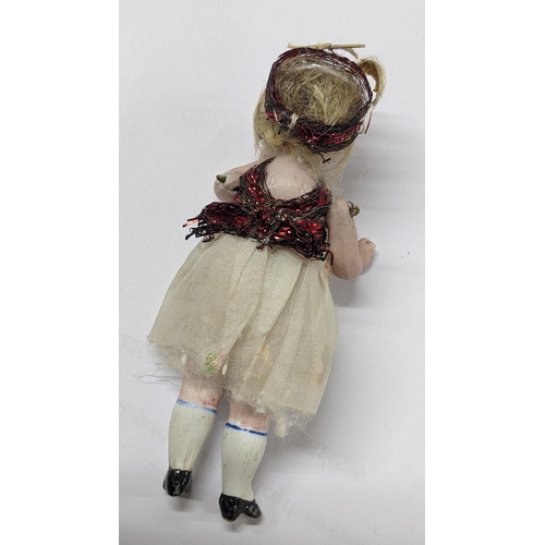 274 - A circa 1900 German miniature bisque doll, possibly Simon & Halbig, 9cm, contained in a Cadbury choc... 