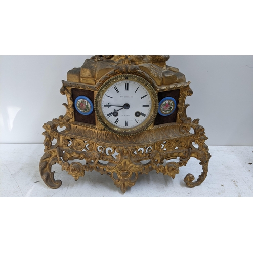 279 - A late 19th century French gilt metal 8-day mantel clock the top fashioned as an angel with a child,... 