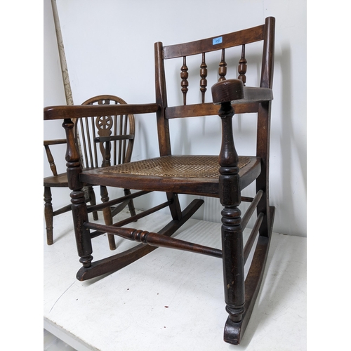 312 - A 19th century cane seated rocking chair turned spindle back out swept arms, on ring turned legs uni... 