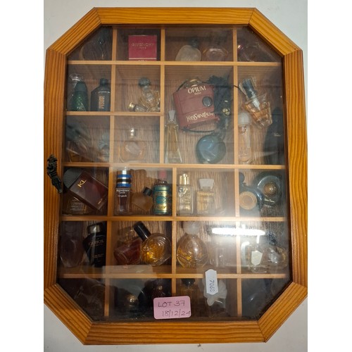 37 - A collection of miniature fragrances in a glazed display case to include YSL Opium, Van Cleefs & Arp... 