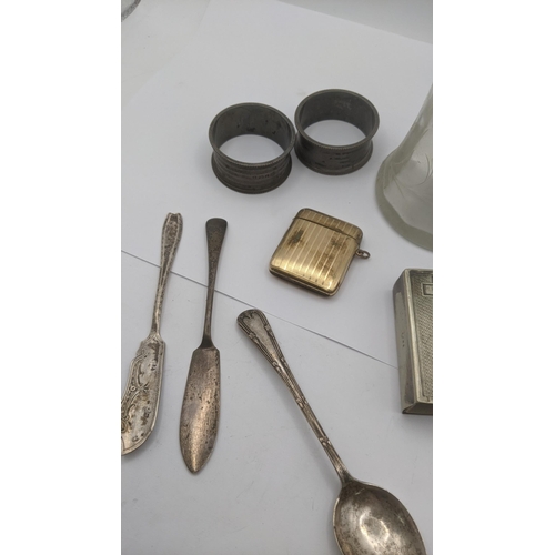 163 - A mixed lot to include a gold plated vesta case, two silver napkin rings, a silver plated matchstick... 