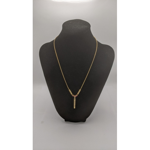 192 - A 9ct yellow gold necklace with a 9ct yellow ruby and diamond pendant set with a central brilliant c... 