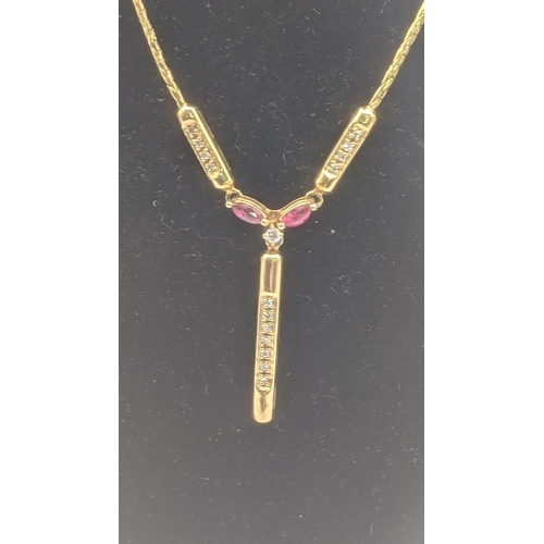 192 - A 9ct yellow gold necklace with a 9ct yellow ruby and diamond pendant set with a central brilliant c... 