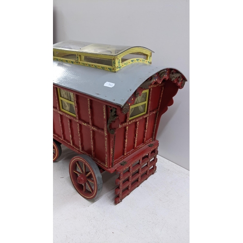 208 - A painted gypsy caravan model complete with contents and porcelain model of a horse, the caravan 39c... 