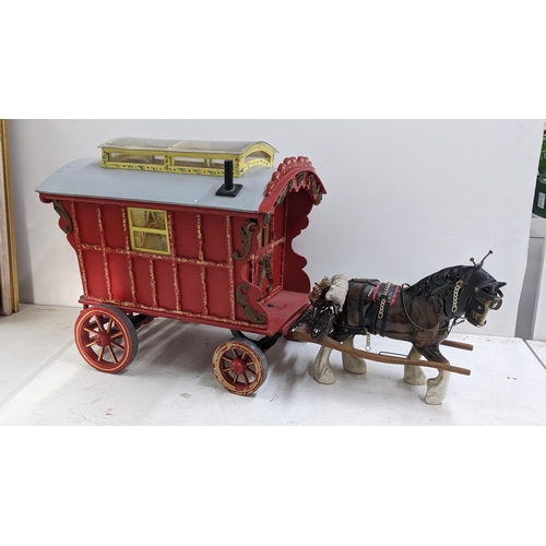 208 - A painted gypsy caravan model complete with contents and porcelain model of a horse, the caravan 39c... 